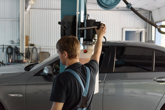 Mechanic lifting car up in garage