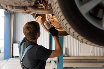 Technician investigating car with lamp