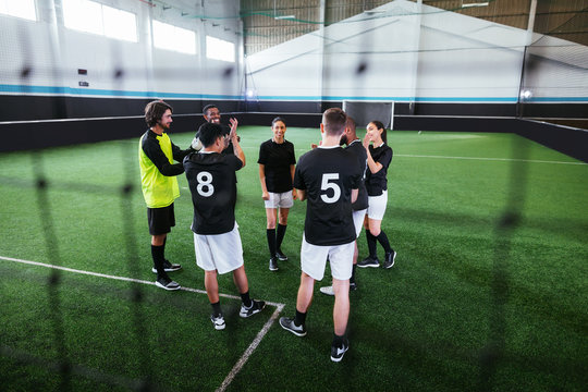 Group of young players in indoor football field.