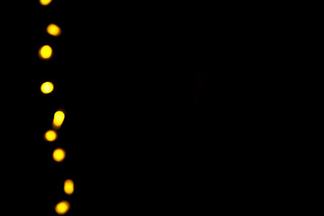 Abstract gold bokeh line on black background. Defocused yellow lights, abstract texture
