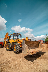 Yellow bulldozer excavator on the construction site warehouse working machine