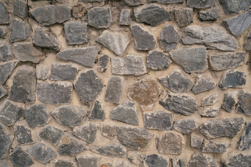 Backdrop of textured uneven gray stone blocks in wall design