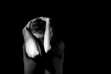 dramatic black and white photography, a man holding his head, in an emotional pose