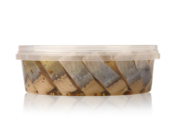 Marinated fish in a plastic container. Pieces of pickled herring in the package from the store on a...