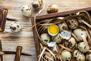 Quail eggs. Flat lay composition with small quail eggs in the wooden box on the natural wooden...