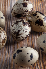 Quail eggs. Flat lay composition with small quail eggs on the natural wooden background. One broken...