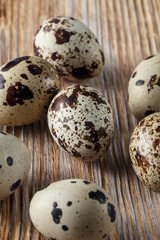 Quail eggs. Flat lay composition with small quail eggs on the natural wooden background. One broken...