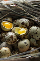 Quail eggs. Flat lay composition with small quail eggs on the natural wooden background. One broken...