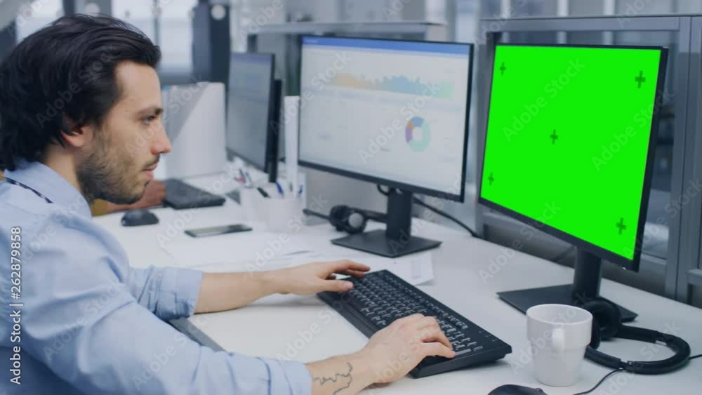 Poster over the shoulder shot of motivated office worker using green mock-up screen desktop computer in the