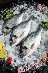 Fresh raw dorado fish and food ingredients on table