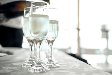 glasses of champagne are on a white tablecloth on the table 