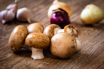 Fresh whole brown champignon mushrooms on vintage wooden table