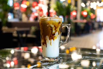 Glass with cold brew coffee and milk on wooden table