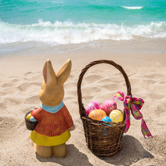 Beach Easter background with bunny and color eggs