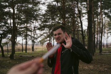 Man refusing to take cigarette. Crop female hand offering cigarette to male meeting stop gesture and refusal to smoke	