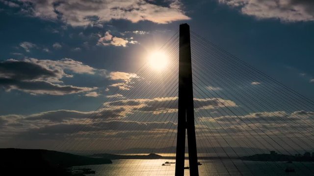 Vladivostok, Prmorsky Krai / Russia - 04 18 2019: Frame from the drone of the bridge cable in the rays of sunset