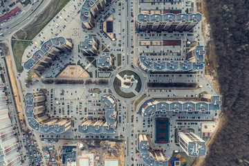 Top down aerial view of round road intersection with cars and new modern buildings, drone shot
