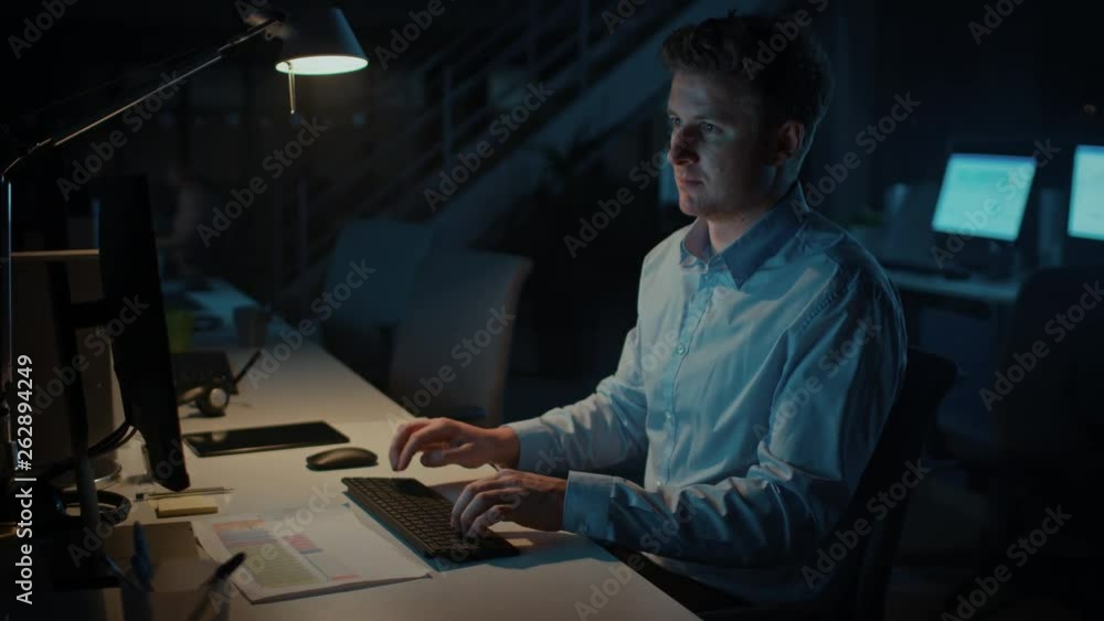 Poster portrait of ambitious and confident businessman uses desktop computer, typing on a keyboard, monitor