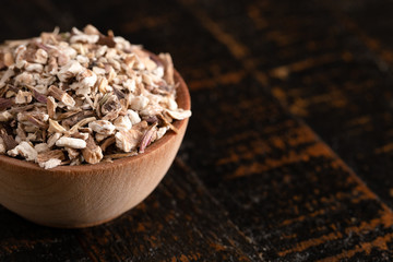 Bowl of Dehydrated Dandelion Root on a Rustic Wooden Table