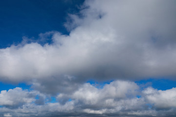 blue sky with white and grey clouds to horizon