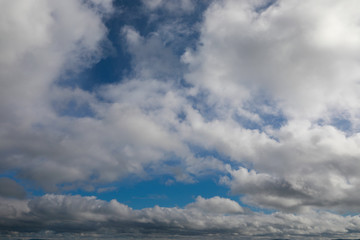 blue sky with white and grey clouds to horizon