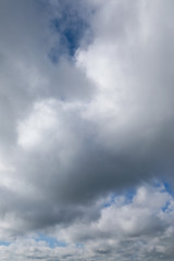 Fototapeta na wymiar blue sky with grey and white clouds portrait orientation