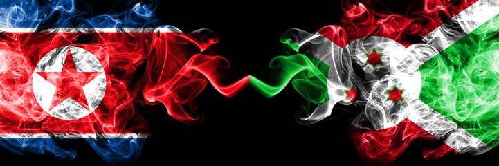 North Korea vs Burundi, Burundian smoky mystic flags placed side by side. Thick colored silky smoke flags of North Korea and Burundi, Burundian.