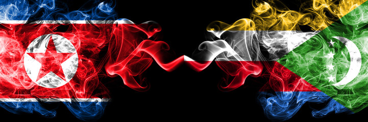 North Korea vs Comoros, Comorian smoky mystic flags placed side by side. Thick colored silky smoke flags of North Korea and Comoros, Comorian.