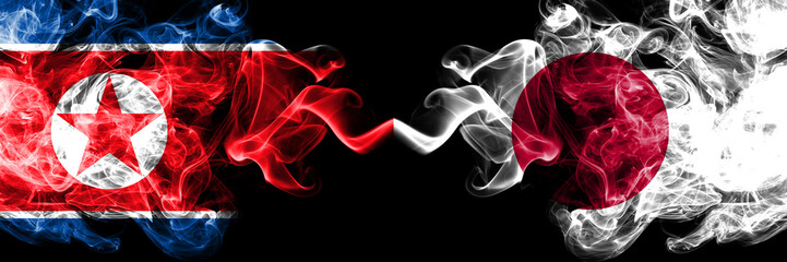 North Korea vs Japan, Japanese smoky mystic flags placed side by side. Thick colored silky smoke flags of North Korea and Japan, Japanese.