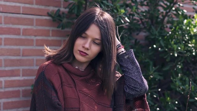 Beautiful young Woman, outdoors, brick wall background, Slow motion clip with gimbal