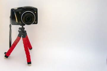 Camera on a tripod.Small nice red tripod for the camera.