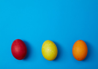 Three easter eggs on blue background