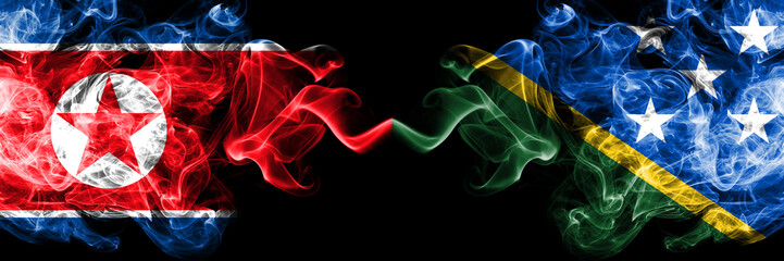 North Korea vs Solomon Islands smoky mystic flags placed side by side. Thick colored silky smoke flags of North Korea and Solomon Islands.