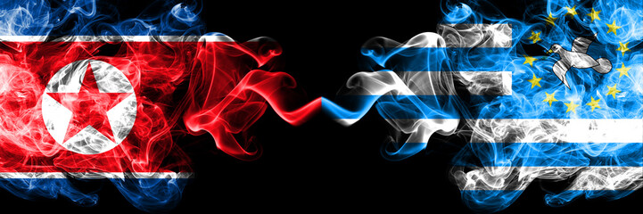 North Korea vs South Cameroon smoky mystic flags placed side by side. Thick colored silky smoke flags of North Korea and South Cameroon.