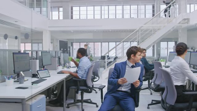 In Modern Office: Diverse Team of Managers and Specialists Work on Computer, Have Discussion with Colleagues and on the Phone. Young and Motivated Business people in Open Office.
