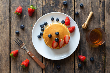 Delicious pancakes with Strawberry and blueberry on wooden table.top view
