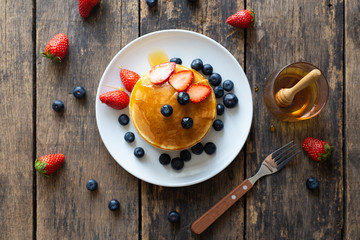 Delicious pancakes with Strawberry and blueberry on wooden table.top view