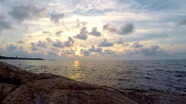 Time lapse for golden sunset in beach with moving clouds.
