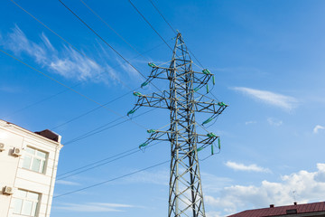 мApartment building with high voltage electric pylon transmitting electricity by wire. Power line...