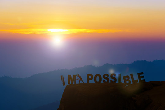 Silhouette man pushing letters I and M from the rock. Word 'possible' standing sound. Sunrise sky at background. Concept of opportunity,copy space.