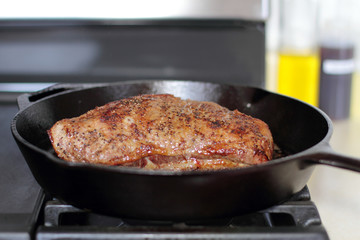 Tri-tip roast in a cast iron pan resting on the oven.
