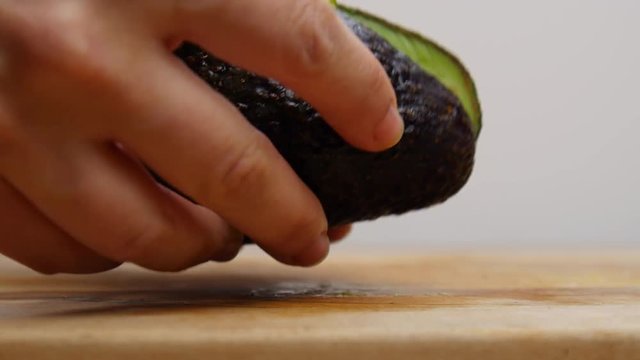 Cutting open an avocado with a knife.