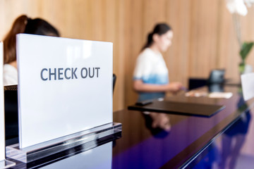 Guest at hotel reception paying with check during check-out