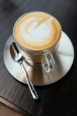 Close up Hot Cappuccino with stainless steel plate. White froth on coffee and milk with copy space.
