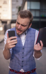 one young furious businessman, holding his phone.