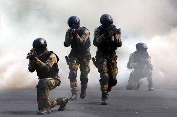 Special force assault team under smoke screen background