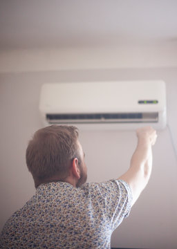 one young man turning on his air conditioner.