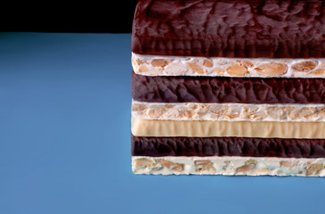 Turron. Typical Christmas food in Spain. Torrone and nougat with nuts. Texture, layers, background. Selective focus.