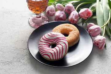 Sugar and Striped-glazed donuts with tea and tulips