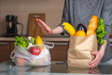 Woman chooses a paper bag with food and refuses to use plastic. Environmental protection and the abandonment of plastic